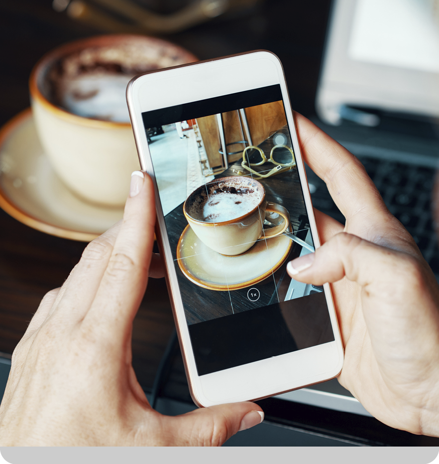 A person is holding a cell phone with a picture of a cup of coffee on it. AI generated content